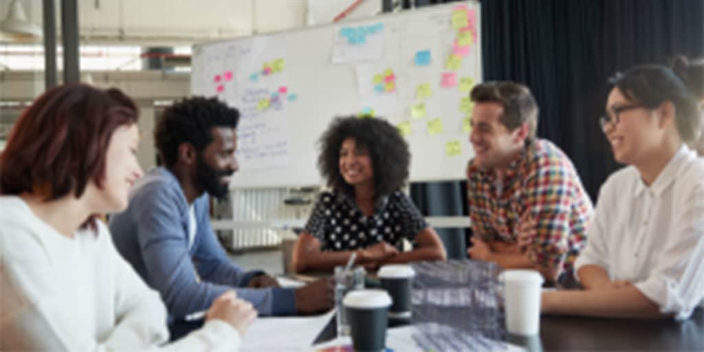 Group sits around a project table working on Transforming public health workforce.